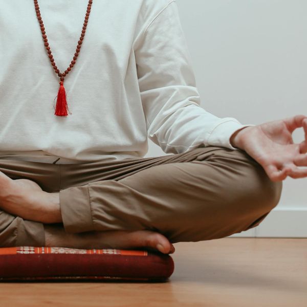 Close-up of a person's hands in a meditative mudra gesture.